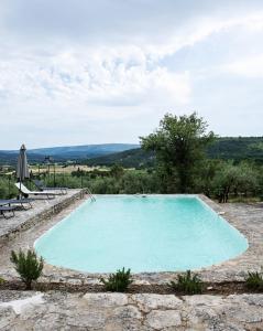 einen Pool mit Blick auf die Hügel in der Unterkunft Les Milles Roches in Gordes