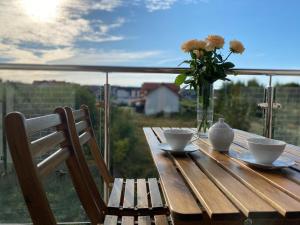 a wooden table with a vase of flowers and a vase of flowers at Royal Blue Port in Rowy