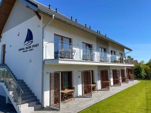 a large white building with a balcony and tables at Royal Blue Port in Rowy