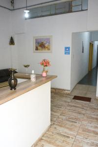 a lobby with a counter with flowers on it at Pousada Santana in Cachoeira Paulista