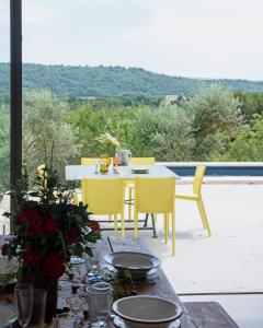 einen Tisch und Stühle auf einer Terrasse mit Aussicht in der Unterkunft l'Atelier des Milles Roches in Gordes