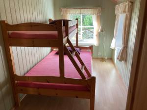 two bunk beds in a room with a window at Roste Hyttetun og Camping in Os