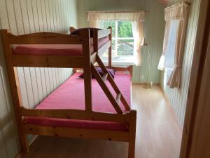 a bed sitting in a room next to a window at Roste Hyttetun og Camping in Os