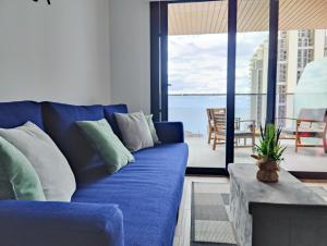 a blue couch in a living room with a view of the ocean at SUNSET WAVES apARTs by RB in Benidorm