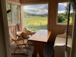 Habitación con mesa, sillas y ventana en Roste Hyttetun og Camping, en Os