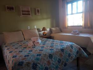 1 dormitorio con 1 cama con toallas en Pousada Mar a Mar, en Búzios