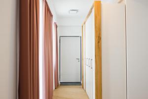 a hallway with orange curtains and a mirror at Pink Sahara near City Center in Oradea