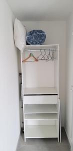 biała szafa z białymi półkami i poduszką w obiekcie Equipée 2 personnes proche Paris w mieście Argenteuil