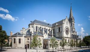 duży budynek z kościołem z wieżą zegarową w obiekcie Equipée 2 personnes proche Paris w mieście Argenteuil