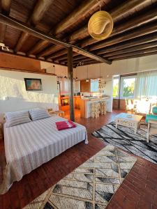 a bedroom with a bed and a living room at Stupa Eco Vila in Barra de Ibiraquera