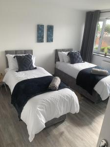 1 dormitorio con 2 camas individuales y ventana en Crowthorne House, beautiful 3 bedroom Home for upto 8 Guests, with sofa bed Cul-de-sac with Private Driveway en Nottingham