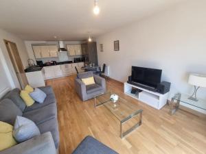 a living room with a couch and a television at Dartford Lodge in Kent