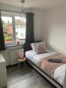 a bedroom with a bed and a window at Crowthorne House, beautiful 3 bedroom Home for upto 8 Guests, with sofa bed Cul-de-sac with Private Driveway in Nottingham
