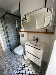 La salle de bains est pourvue d'un lavabo, de toilettes et d'un miroir. dans l'établissement Przytulny apartament, 200m od morza, Gdynia Orłowo, à Gdynia