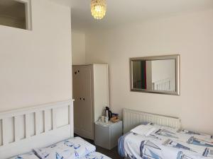 Tempat tidur dalam kamar di SINGER HOUSE BEACH , SLEEPS 6, self GARDEN Always Happy to Help you ,24 Hour Reception , PERFECT for the ELDERLY GROUND FLOOR LARGE GARDEN 2 BEDROOM APARTMENT, PRIVATE GATE & PRIVATE CAR SPACE & KITCHEN , LARGE WALK IN SHOWER , Opposite PAIGNTON PIER