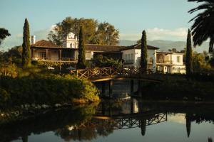 安地瓜的住宿－Villa Bokeh Relais & Châteaux，一座大房子,有一座河上的桥梁