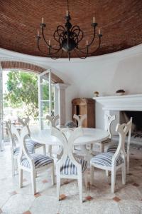 een eetkamer met een witte tafel en stoelen bij Villa Bokeh Relais & Châteaux in Antigua Guatemala
