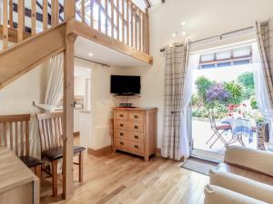ein Wohnzimmer mit einer Treppe und einem TV in der Unterkunft Norbank Cottage in Bressingham