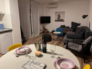 uma sala de estar com uma mesa com pratos e copos de vinho em Šibenik apartment em Sibenik