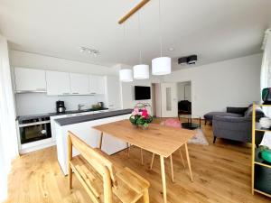 eine Küche und ein Wohnzimmer mit einem Holztisch in der Unterkunft Beim Lanner - Maria in Mondsee