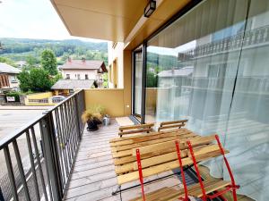 un banco de madera sentado en el balcón de una casa en Beim Lanner - Maria, en Mondsee