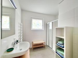 ein weißes Badezimmer mit Waschbecken und Spiegel in der Unterkunft Beim Lanner - Maria in Mondsee