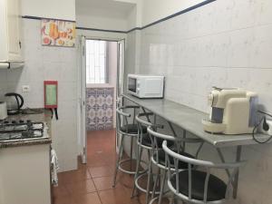 une cuisine avec un comptoir avec des tabourets et un four micro-ondes dans l'établissement Green Charming, à Lisbonne