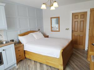 a small bedroom with a bed and a kitchen at Biddy Ban’s in Carnmalin