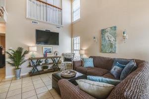 a living room with a couch and a flat screen tv at Flip Flop Inn by Book That Condo in Panama City Beach