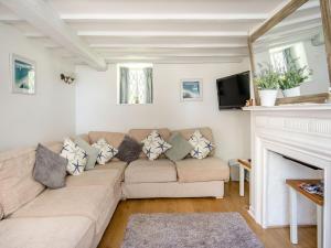 uma sala de estar com um sofá e uma lareira em Lisle Combe Cottage em Saint Lawrence