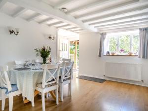 a white dining room with a table and chairs at Lisle Combe Cottage in Saint Lawrence
