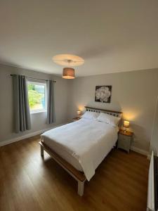 a bedroom with a large bed and a window at Mc's View in Tullyrossmearan