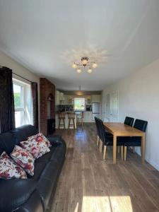 a living room with a couch and a table at Mc's View in Tullyrossmearan