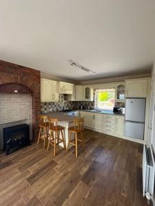 a kitchen with a table and chairs and a fireplace at Mc's View in Tullyrossmearan