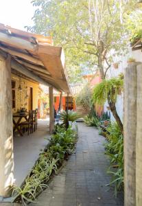 an outdoor patio with a table and some plants at Pousada Solar in Caraíva