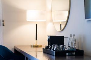 Zimmer mit einem Tisch, einer Lampe und einem Spiegel in der Unterkunft Hotel Gran Plaza & Convention Center in Guanajuato