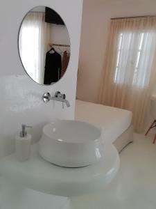 Baño blanco con lavabo y espejo en Helen Studios en Naxos