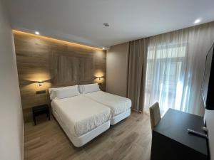 Dormitorio con cama, escritorio y TV en Castilla Guerrero en Málaga