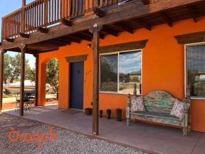 ein orangefarbenes Haus mit einer Bank davor in der Unterkunft Oranch House, Studio & Wilderness in Kanab