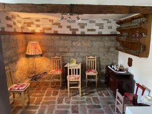 a room with chairs and a stone wall at Apartmani Petkovic 226 in Velika Drenova