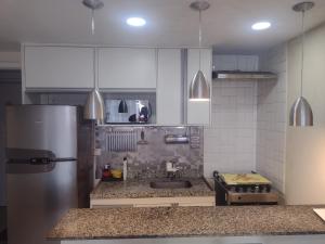 a kitchen with a stainless steel refrigerator and a sink at Porto Real Resort Suites 1 in Mangaratiba