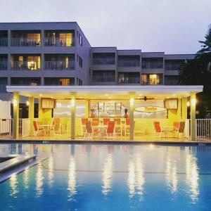 a hotel with a swimming pool in front of a building at Condo less than 5 min from Airport with Sunset Views in Tampa