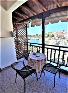 a table and chairs on a balcony with a view at Zefyros Studios in Neos Marmaras