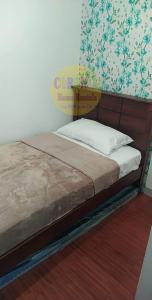 1 cama con cabecero de madera en un dormitorio en Isabelle De Valenzuela Condo Staycation in Marulas Valenzuela en Manila