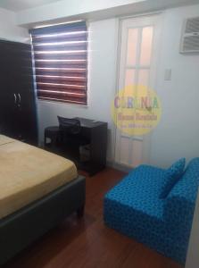 a bedroom with a bed and a chair and a desk at Isabelle De Valenzuela Condo Staycation in Marulas Valenzuela in Manila