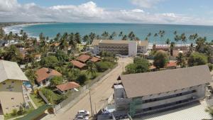 an aerial view of a town with a building and the ocean at Flat em Porto de Galinhas com Piscina Exclusiva in Porto De Galinhas