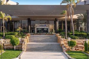 un edificio con scale e palme di fronte ad esso di Radisson Blu Hotel Alexandria ad Alessandria d'Egitto