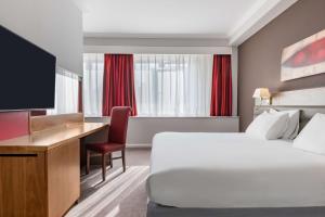 een hotelkamer met een bed, een bureau en een televisie bij Radisson Blu Hotel, Durham in Durham