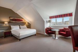 1 Schlafzimmer mit einem Bett, 2 Stühlen und einem Tisch in der Unterkunft Radisson Blu Hotel, Durham in Durham