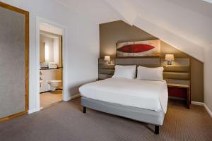 a bedroom with a white bed and a bathroom at Radisson Blu Hotel, Durham in Durham